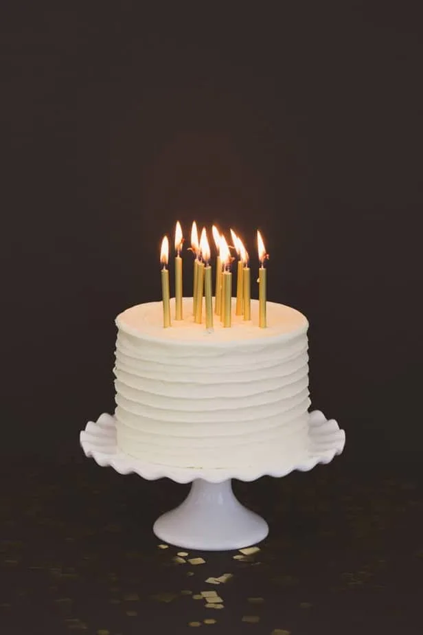 white cake with lit candles on top