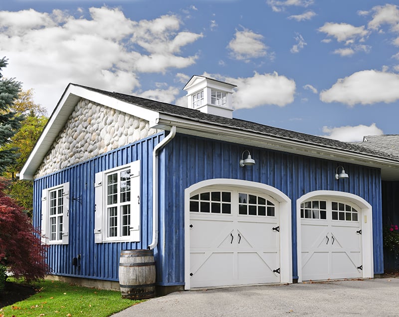 blue garage with white garage doors and windows
