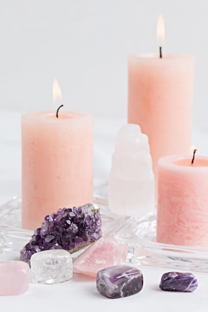 candles, rose quartz, amethyst stones, clear quartz crystals, and selenite tower