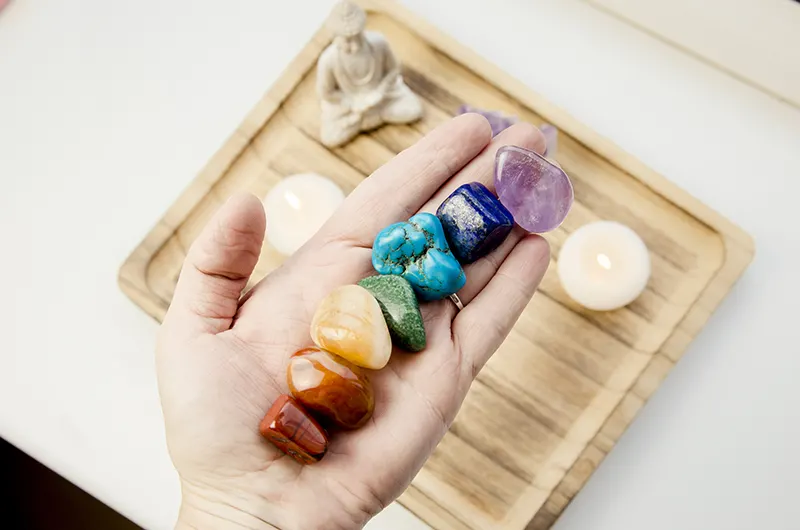 hand holding 7 chakra crystals