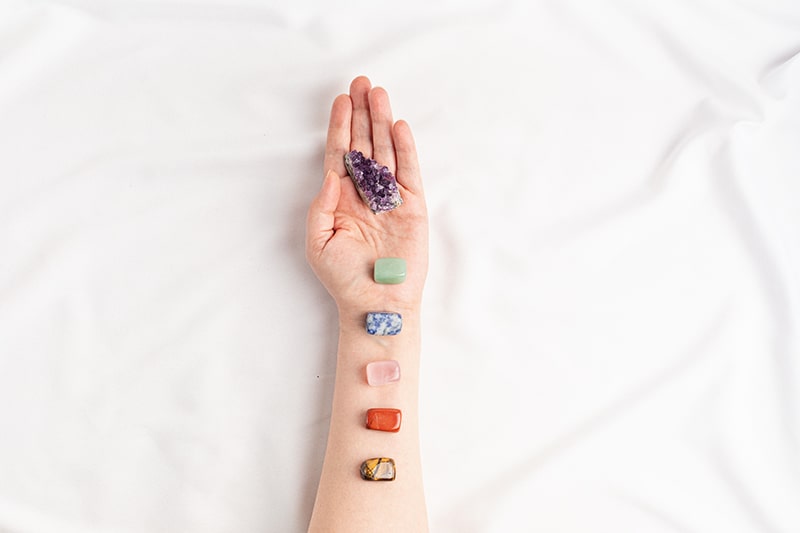 chakra crystals in a row on woman's arm