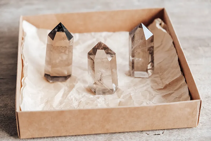 three smoky quartz crystals in a box