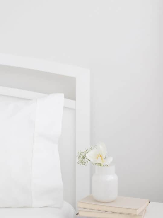 vase of flowers and books on nightstand
