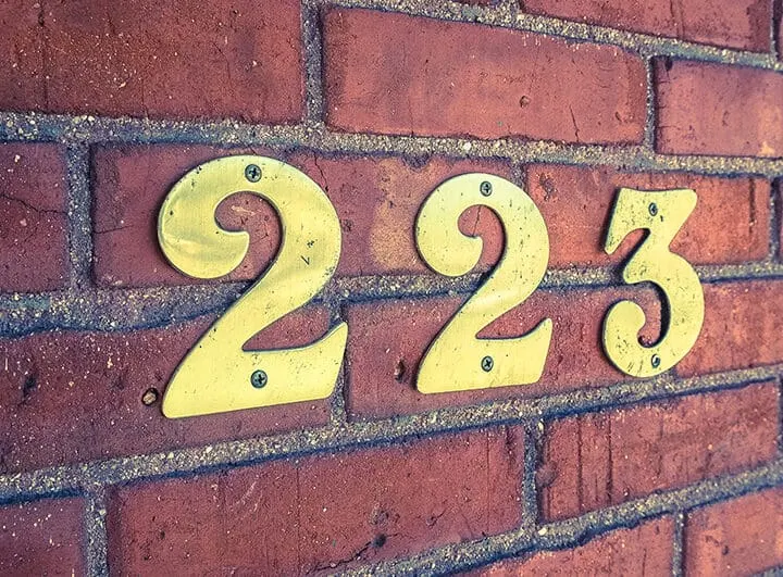 house number 223 on brick wall
