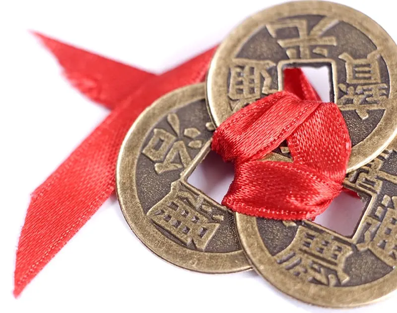 3 feng shui coins tied with red ribbon