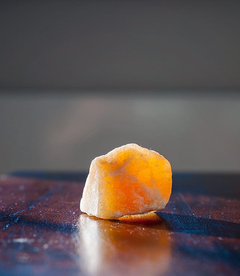 orange calcite crystal on a table