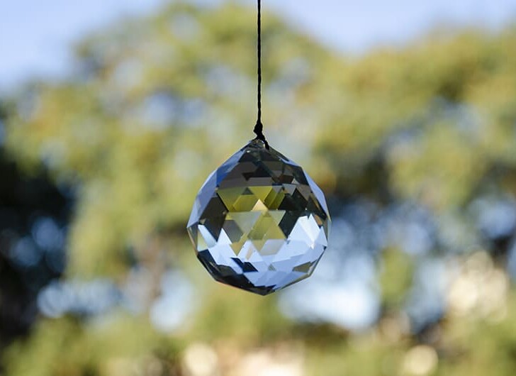 feng shui faceted crystal ball hanging in a window to attract good luck