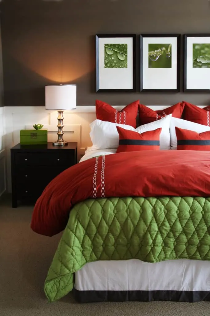 bedroom with green artwork and red, white, and green bedding