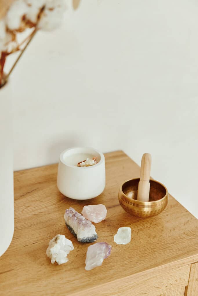 candle, crystals, and sound bowl on a dresser