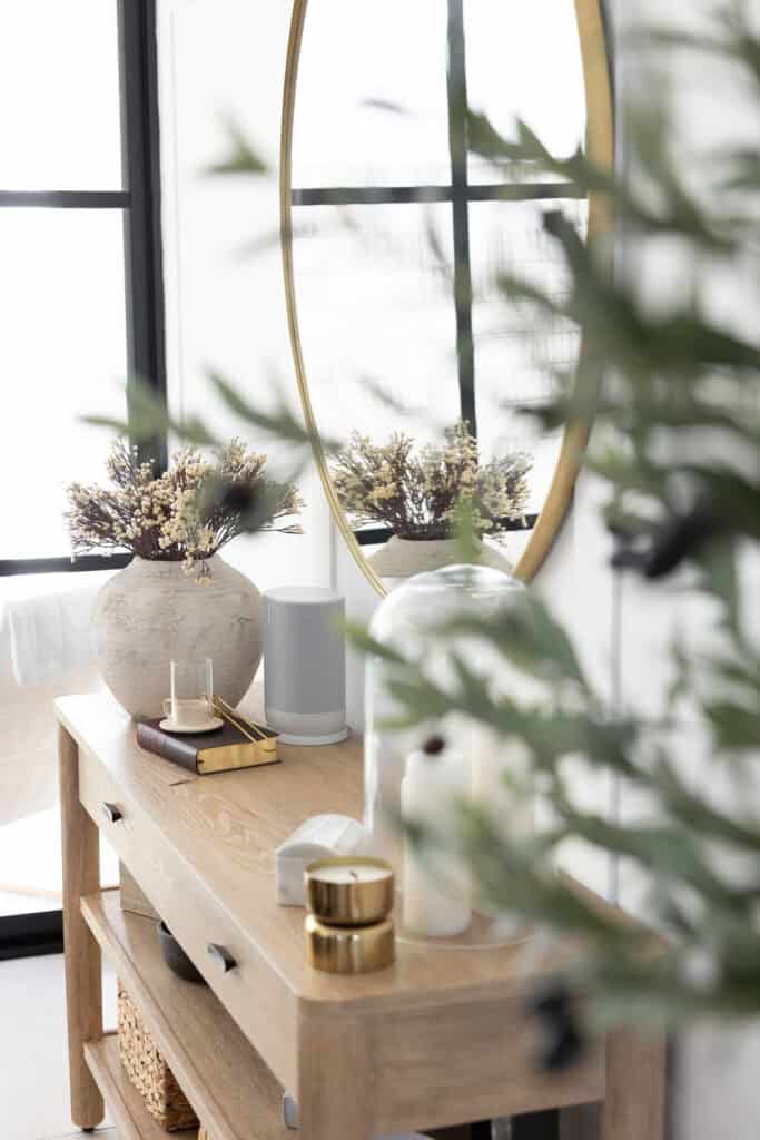 entryway of home with mirror, candles, and plants